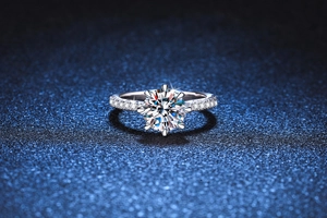 Vue macro d'une bague moissanite à six griffes avec pierres sur fond bleu scintillant