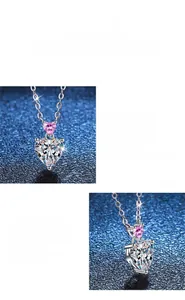Macro detail of double heart pendant with pink and white moissanite in polished silver