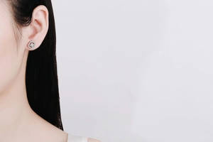 Close-up of S925 silver rectangle stud earrings with moissanite halo on female ear