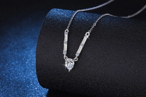 Macro shot of pear-cut moissanite pendant on a silver necklace with sparkling details