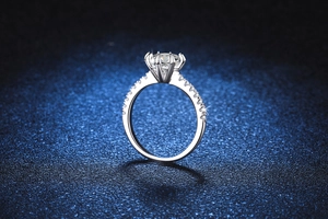 Détail macro d'une bague moissanite à six griffes avec pavage sur fond de velours