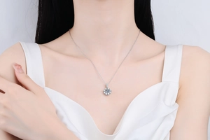 Close-up of 1ct round moissanite pendant on s925 silver chain worn by a model