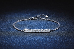 Macro shot of silver tennis bracelet with brilliant-cut moissanite stones and heart charm