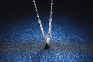 Macro view of S925 silver necklace with V-shaped diamond frame and pear-cut pendant