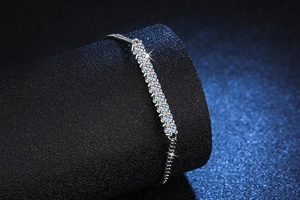 Detail of adjustable silver chain bracelet featuring nine round sparkling moissanite stones