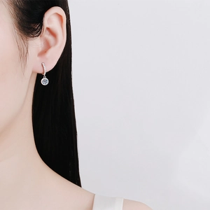 Elegant S925 sterling silver hoop earrings with round Moissanite pendant worn by model