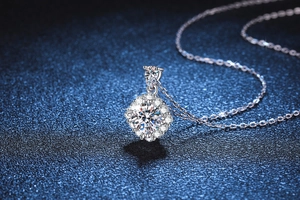 Macro view of s925 silver necklace featuring a sparkling round and pear-cut moissanite pendant