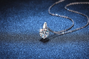 Gros plan d'un pendentif en moissanite taille brillant sur une fine chaîne en argent