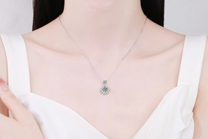Close-up of s925 silver necklace with 1-carat round Moissanite pendant worn by model