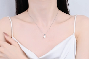 Elegant s925 silver necklace with moissanite and round pearl worn on a model collarbone