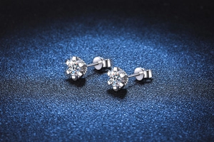 Macro shot of 925 sterling silver six-prong moissanite stud earrings in snowflake design