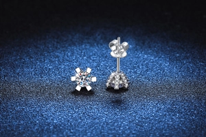 Macro detail of snowflake moissanite earrings with six-prong setting and butterfly back