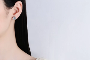 Close-up of classic six-prong s925 silver moissanite stud earring worn on model's ear