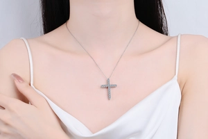 Detail of s925 silver cross necklace with 1.6ct moissanite on a female model