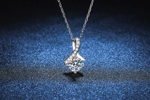 Macro detail of S925 silver 1ct Moissanite pendant with ribbon design on blue background
