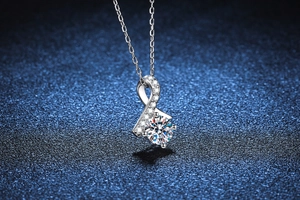 Macro shot of S925 silver bow pendant with a 1-carat moissanite on starry background