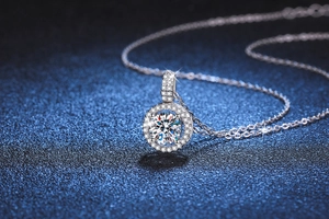Macro shot of 1ct Moissanite halo pendant in s925 silver on deep blue textured background