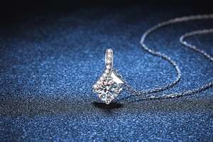 Macro shot of 1ct Moissanite pendant with curved diamond-set bow design and O-chain