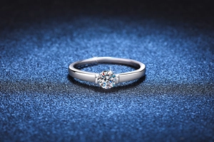 Macro shot of a 925 sterling silver moissanite ring on a starry blue texture