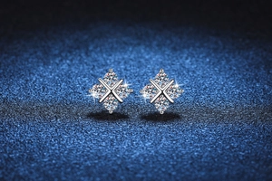 Dettaglio macro di orecchini a lobo in argento S925 con moissanite e design a croce x