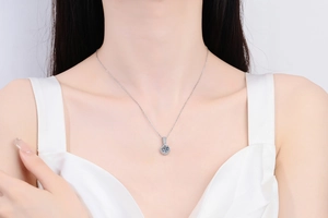 Gros plan d'un collier pendentif moissanite 1ct sur un modèle avec serti halo classique