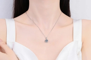 Moissanite pendant necklace shown on neck with brilliant round cut and pavé diamonds