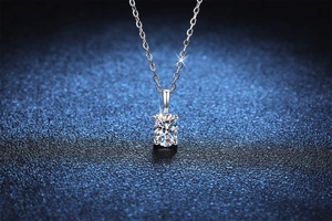Detailed macro shot of 1 carat round moissanite pendant with four-prong silver setting