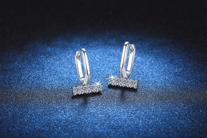 Detail of S925 silver U-shape hoop earrings with a row of four sparkling round diamonds