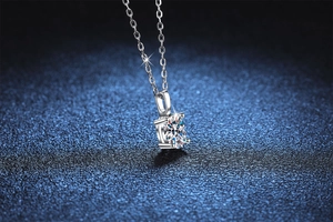 Macro shot of a 1 carat round moissanite silver pendant with 4-prong setting details
