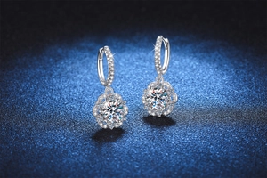 Macro detail of S925 silver rose-shaped earrings with sparkling moissanite on blue background