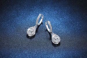Macro shot of pear-shaped moissanite earrings in silver with halo setting detail