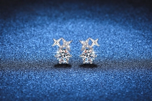 Gros plan des boucles d'oreilles étoile en argent S925 avec moissanite sur fond ciel étoilé