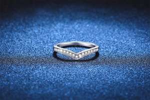 Macro detail of V-shaped S925 silver ring with shimmering pavé set moissanite stones