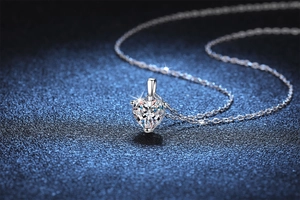 Macro shot of s925 silver heart pendant with 1ct moissanite on blue background