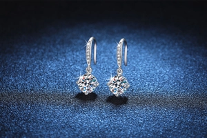 Macro shot of silver drop earrings with sparkling round moissanite in classic 4-prong setting