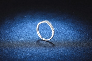 Macro detail of V-shaped S925 silver ring with shimmering pavé set moissanite stones