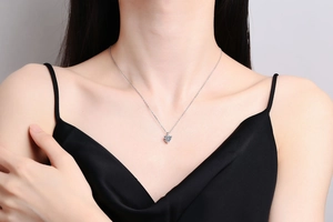 Detail shot of a heart-cut moissanite pendant on s925 silver necklace worn by a model