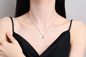 Close-up of S925 silver necklace with teardrop moissanite pendant on a model's neck