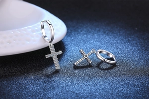 Macro detail of S925 sterling silver cross earrings with shimmering moissanite stones
