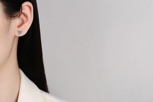 Detail of s925 silver stud earrings with three blue moissanite petals on earlobe
