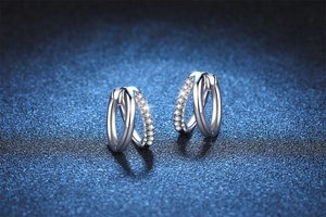Macro detail of S925 sterling silver earrings with moissanite pavé in a double hoop design
