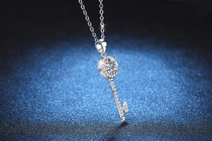Vue macro d'un pendentif clé en argent avec une pierre moissanite ronde brillante