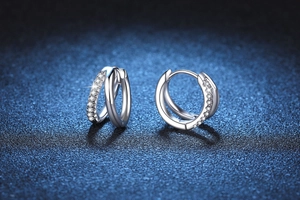 Macro shot of S925 sterling silver hoop earrings with interlocking diamond pavé rings