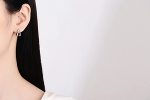 Close-up of elegant double-layered silver hoop earrings with pavé diamonds on a model