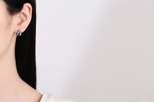 Close-up of S925 silver ear cuff with blue stones on a model ear in minimalist style