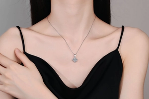 Détail d'un collier en argent s925 avec pendentif moissanite bleue porté sur un modèle