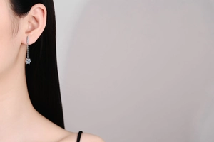 Close-up of S925 silver tassel drop earring with a six-prong Moissanite diamond on a model