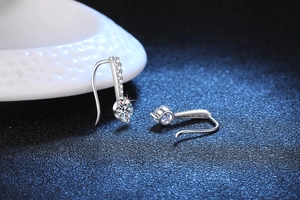 Detailed macro view of S925 silver angel tear earrings with Moissanite stones on blue base