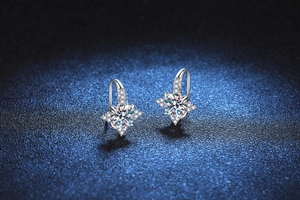 Detail of S925 silver hook earrings with a star-shaped moissanite center stone