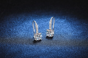 Gros plan de boucles d'oreilles en argent 925 avec moissanite à quatre griffes sur bleu